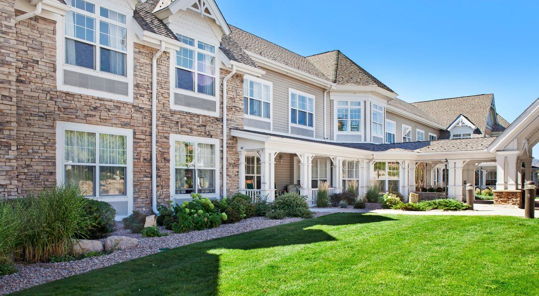 A well-maintained townhouse with a brick facade and lush green lawn.