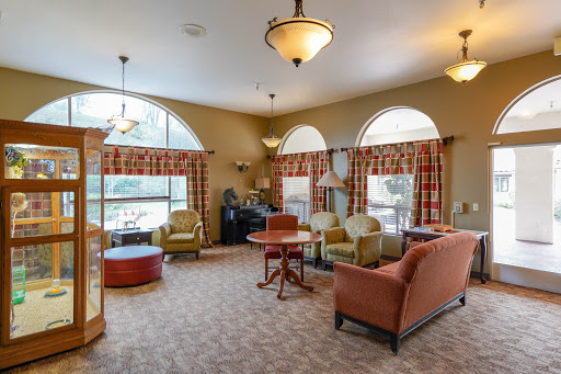A cozy living room with comfortable seating and natural light flowing through large windows.