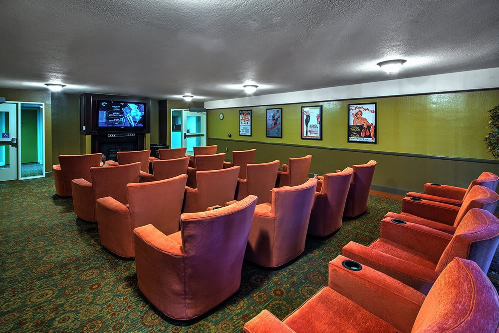 A cozy home theater setup with comfortable seating and a projector screen surrounded by movie posters.
