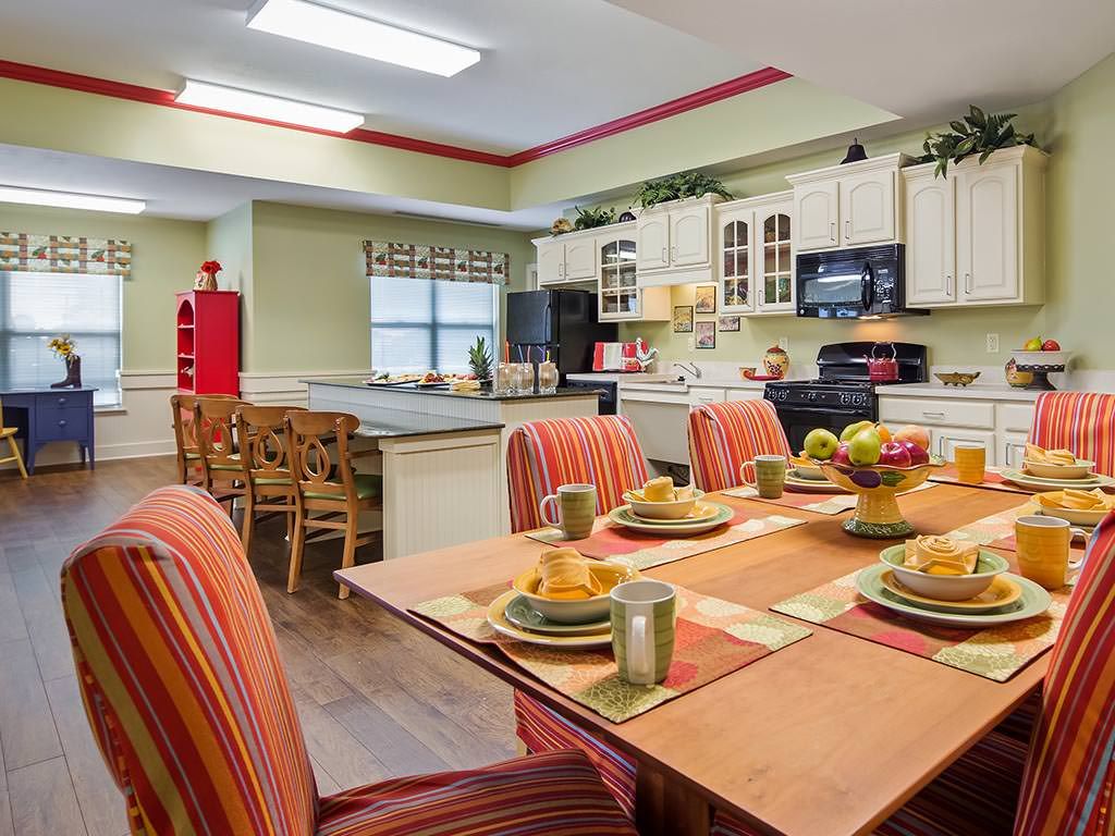 A vibrant kitchen and dining area featuring a colorful table setting with striped chairs and modern decor.