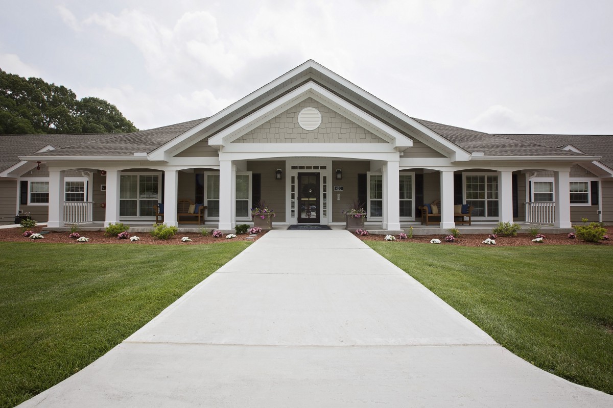 A beautiful residential home with a well-maintained front lawn and prominent columns.