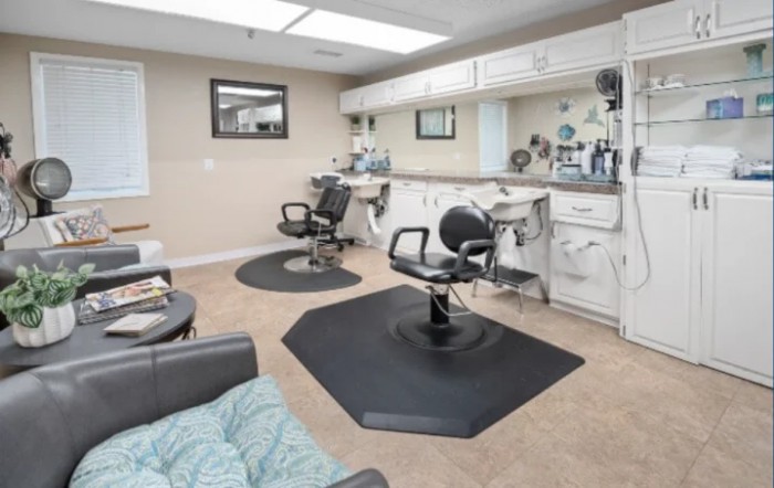 A clean and organized barbershop with two styling chairs and mirrors.