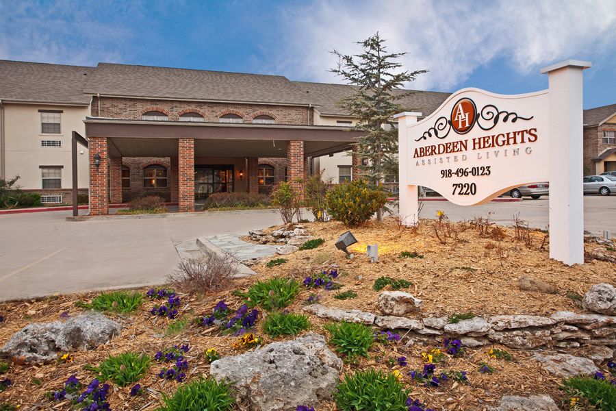 Front entrance of a hotel with signage and landscaped surroundings.