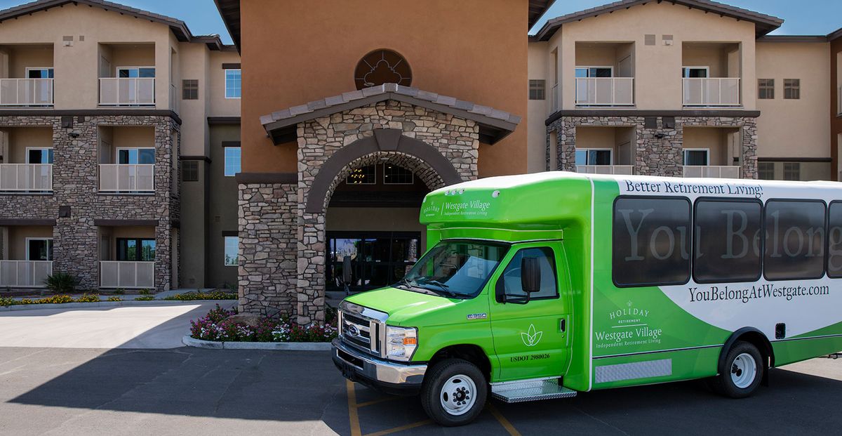 A green shuttle bus parked in front of a hotel entrance.