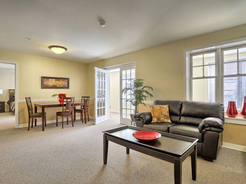 A well-lit living room with a cozy seating arrangement and a dining area.