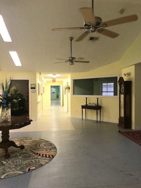 A spacious hallway with ceiling fans and a grandfather clock.