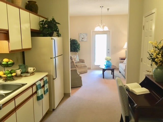 A cozy apartment with an open kitchen leading into a comfortable living room.