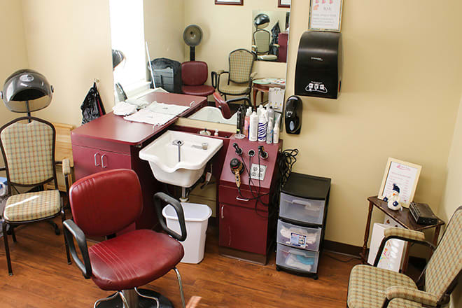 Interior of a hair salon with chairs, sink, and hair products.