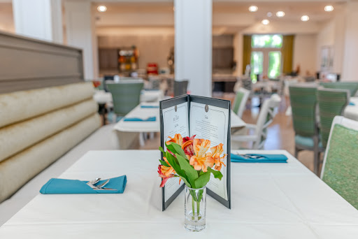 A beautifully arranged dining table with a menu and fresh flowers, showcasing a modern restaurant interior.