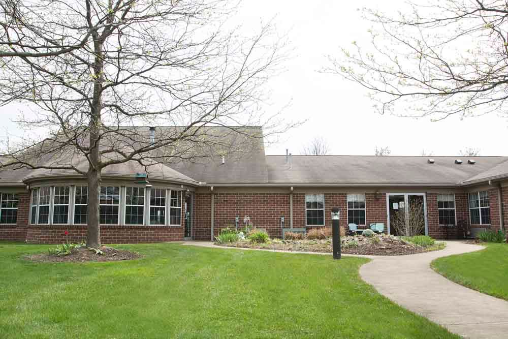 A view of a single-story house with a well-maintained lawn and garden.