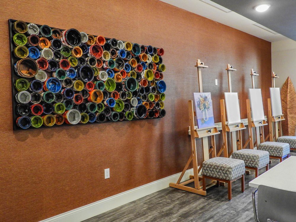 An art studio with easels and a colorful wall installation.