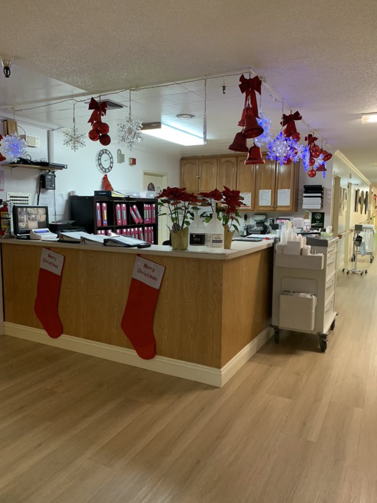 A hospital nursing station decorated with Christmas bows, stockings, and festive ornaments.