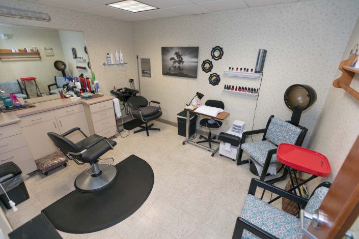 A cozy hair salon with a barber chair, mirror, and a waiting area.
