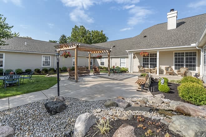 A beautifully landscaped backyard with a pergola and outdoor seating area.