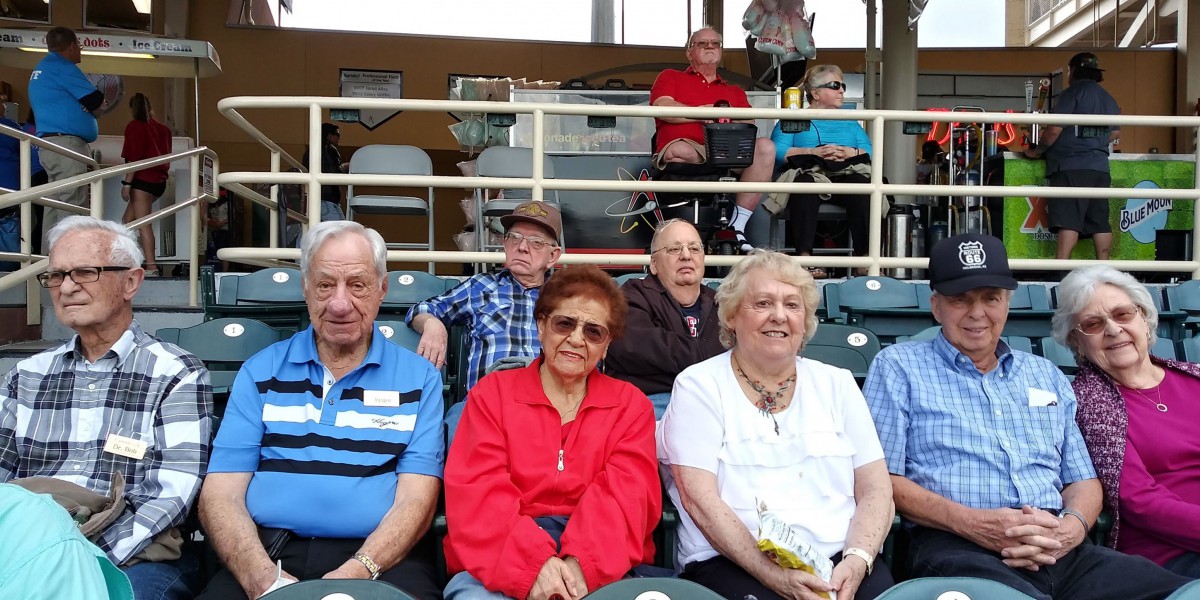 A group of people seated at an outdoor event.
