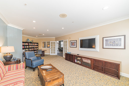 A spacious and inviting living room with comfortable seating and a bookshelf, perfect for relaxation.