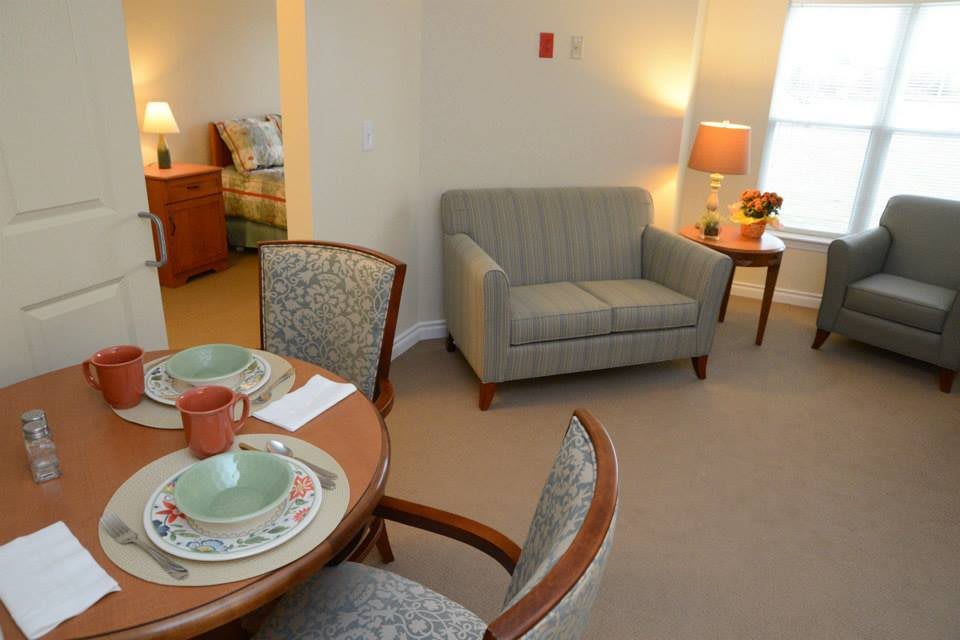 A cozy living and dining space with a sofa, dining table, and warm lighting.