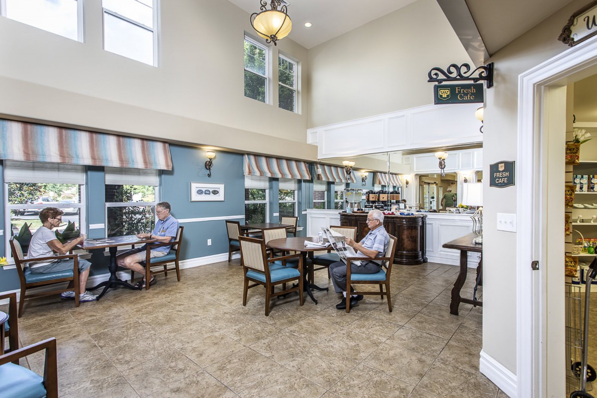 A cozy dining area with people seated at tables, enjoying a relaxed atmosphere with bright natural lighting.