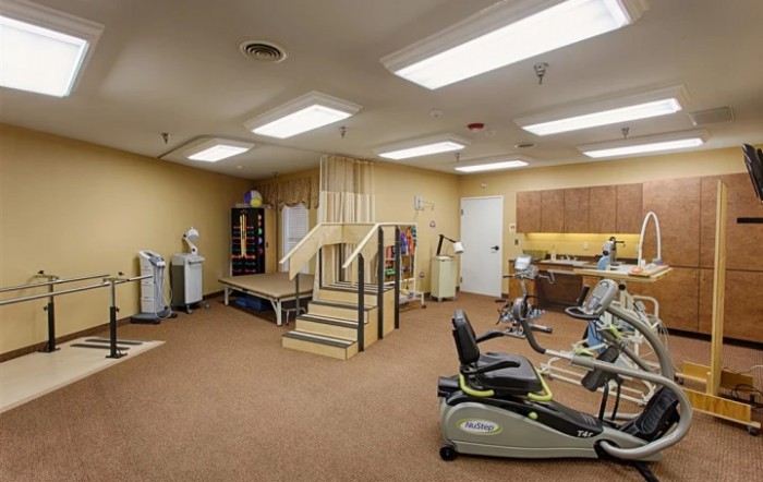 A rehabilitation room equipped with exercise machines and a staircase for physical therapy.