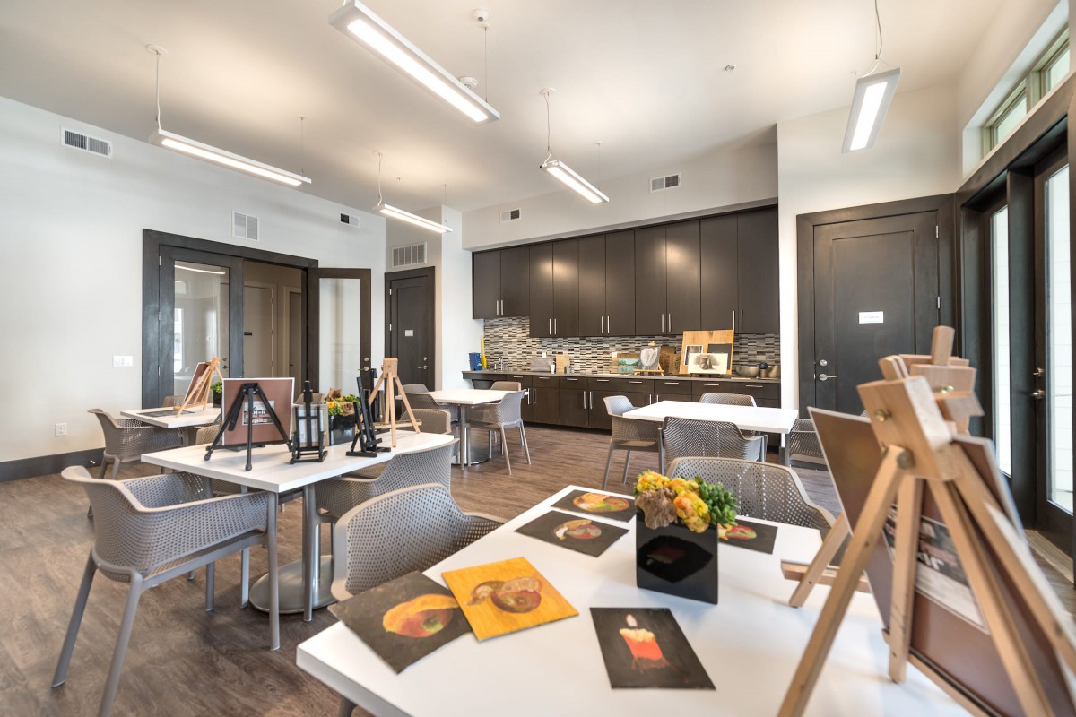 A well-lit art studio with easels and paintings on display.