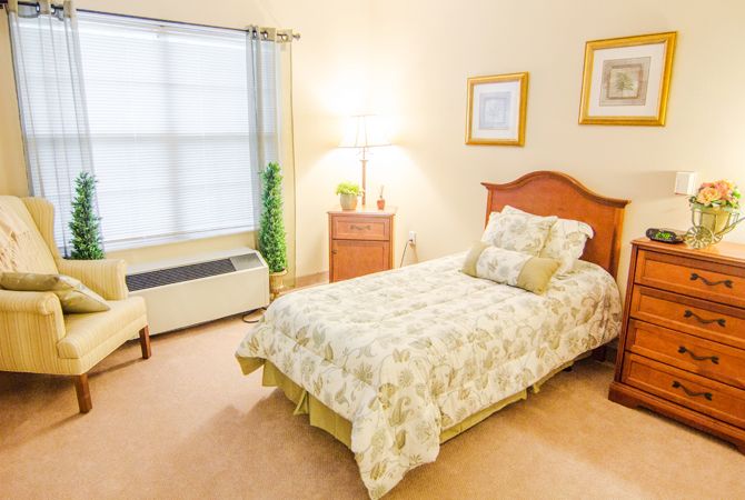 A cozy bedroom with a single bed, soft lighting, and simple decor.