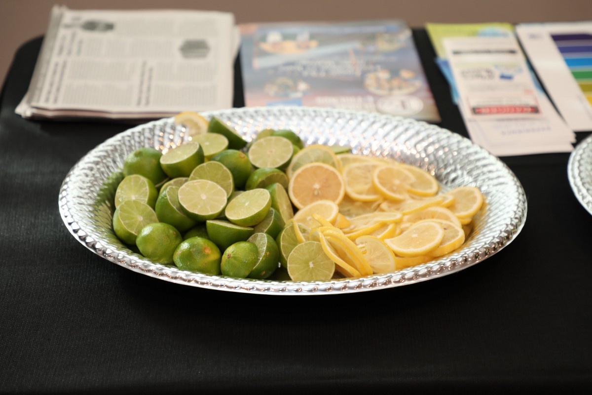 A tray containing sliced lemons and limes on display.