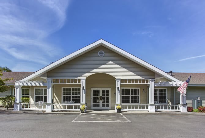 A symmetrical building with a prominent entrance and multiple windows under a clear blue sky.