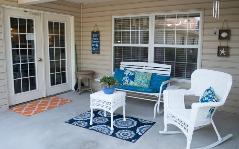 Cozy porch with wicker furniture and decorative elements.