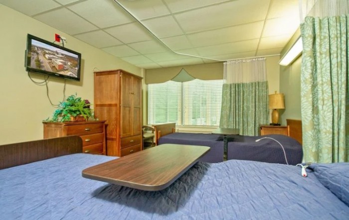 A cozy bedroom with wooden furniture and a large window.