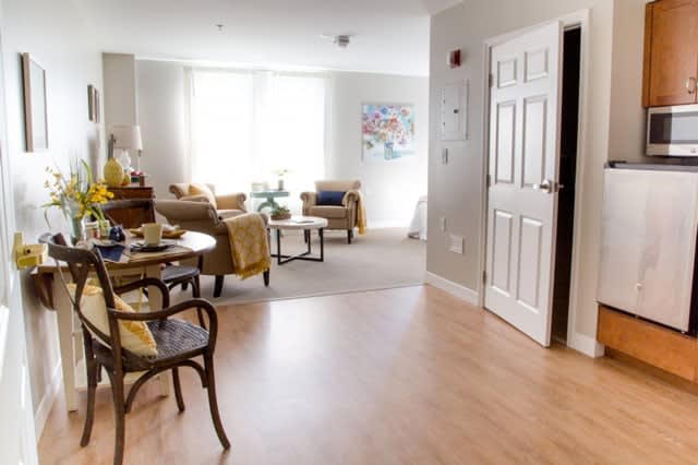 A bright and cozy living room with comfortable armchairs and a wooden floor.