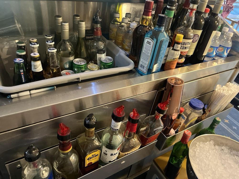 A variety of liquor bottles arranged on a bar shelf.