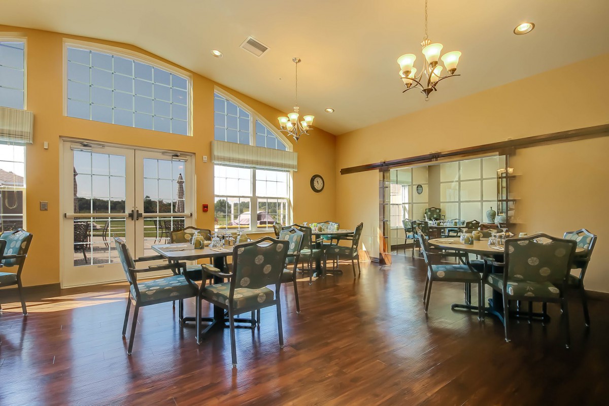 A spacious dining area with large windows and elegant chandeliers.