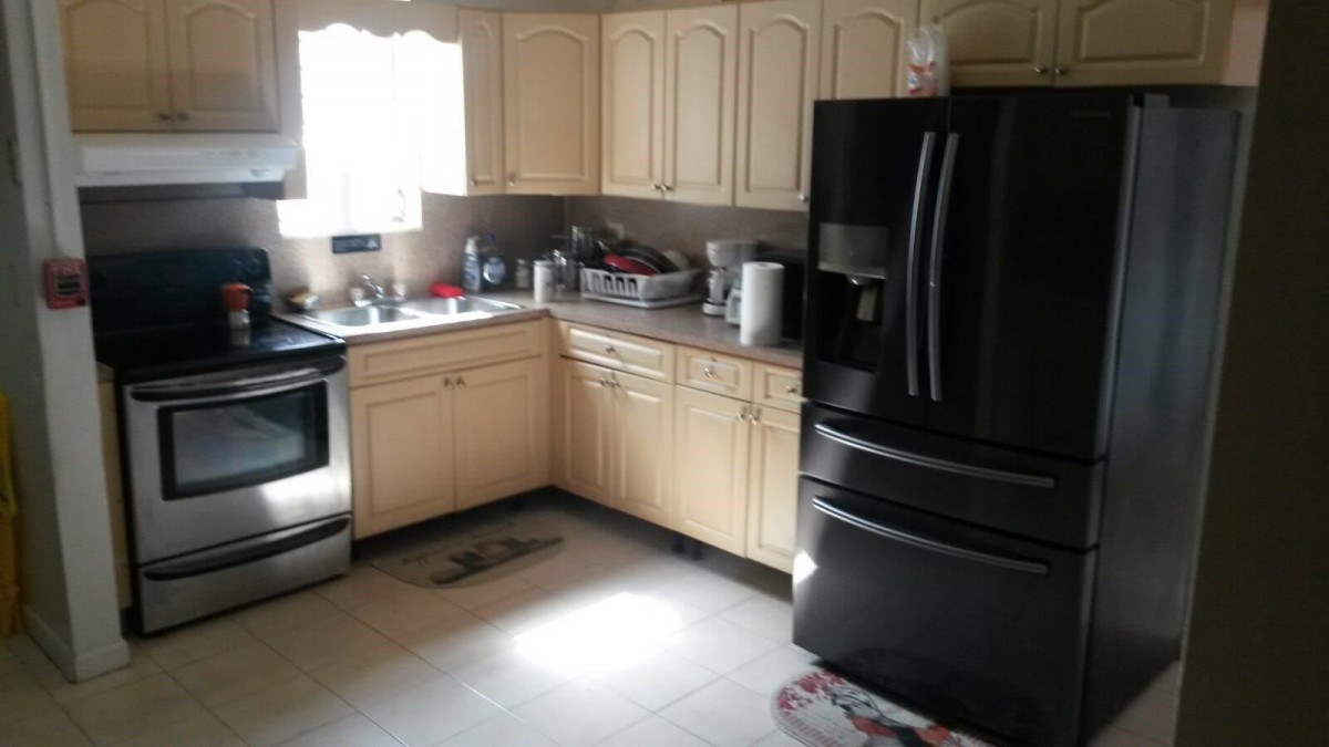 A modern kitchen with wooden cabinets and black appliances.