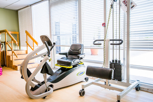 A modern fitness area featuring various exercise machines designed for rehabilitation and workouts.