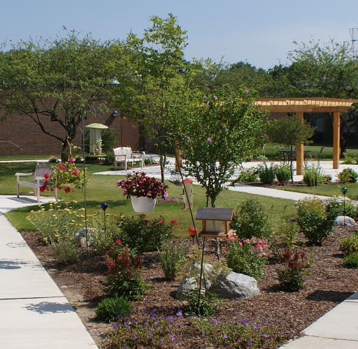 A serene outdoor garden space featuring neatly arranged plants, pathways, and seating areas.