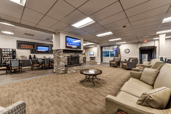 A spacious lobby with comfortable seating, a fireplace, and multiple televisions.