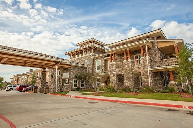 A stone building with a covered entrance under a partly cloudy sky.