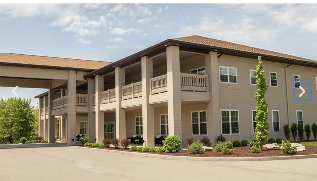 A two-story apartment building with balconies and landscaped surroundings.