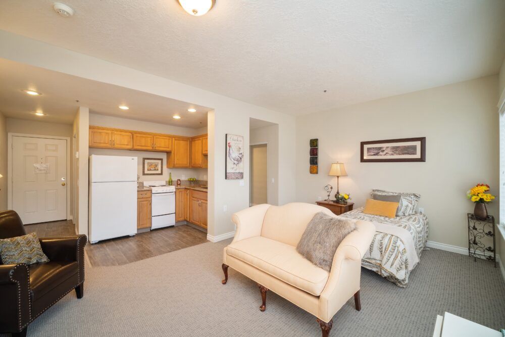 A cozy studio apartment with an open-concept design, featuring a living area, small kitchen, and bedroom.