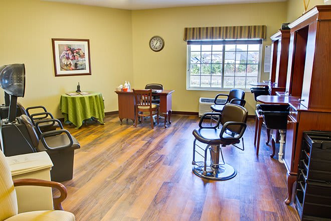 A cozy salon interior with chairs, mirrors, and a wooden floor.