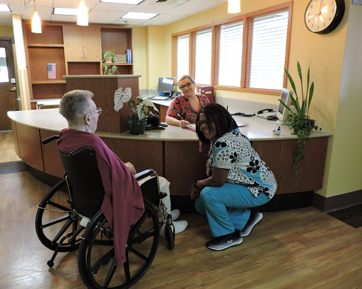 A warm interaction at the reception area, showcasing care and support for a senior citizen.