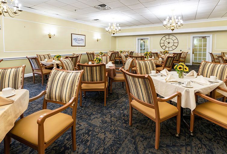 A well-set dining room with striped chairs and elegant lighting.
