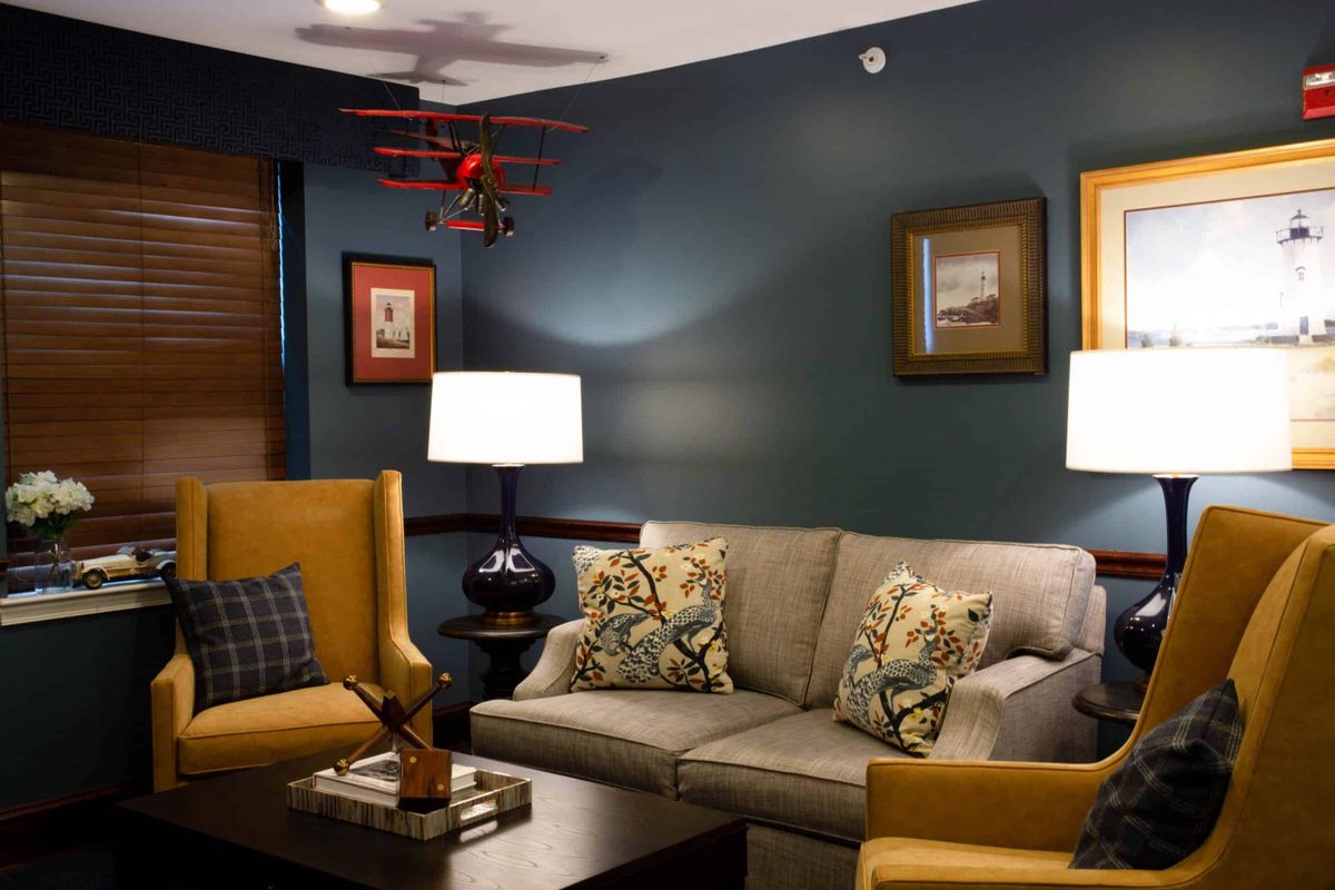 A cozy living room with elegant decor, featuring a comfortable sofa, armchairs, and stylish lighting.
