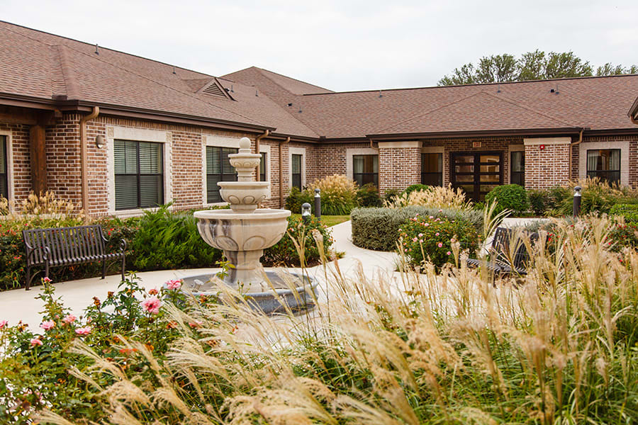 A charming building with a central fountain and well-maintained garden.