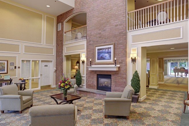 A spacious hotel lobby with a cozy seating area and a fireplace.