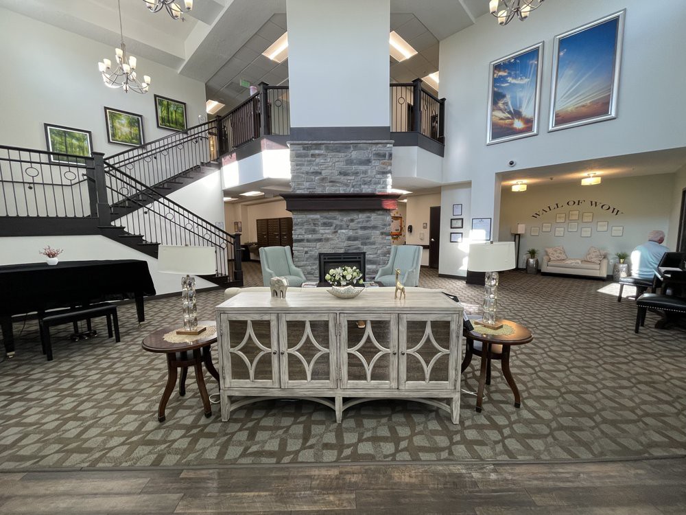 A beautifully designed lobby featuring elegant furniture, a staircase, and artistic wall decorations.