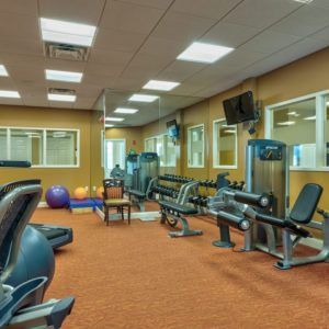 A well-equipped gym with various exercise machines and fitness equipment.