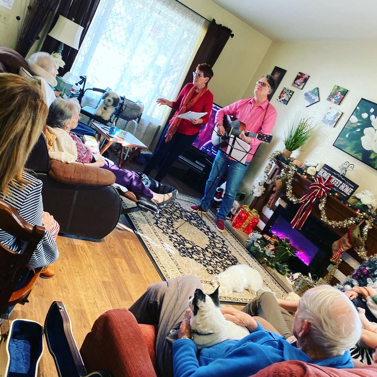 A family gathering in a cozy living room with music and conversation, accompanied by a pet cat.