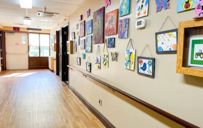 A hallway adorned with various paintings and artwork displayed on the walls.