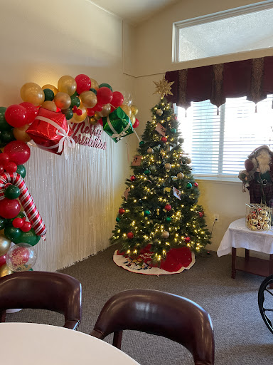 A beautifully decorated corner for Christmas featuring a vibrant tree, festive balloons, and cozy seating.